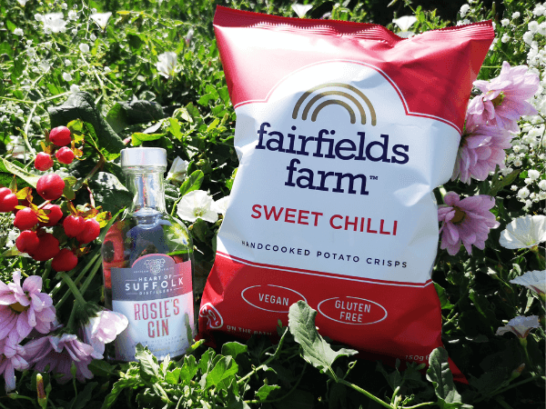 A bottle of Rosie's Gin from Hear of Suffolk Distillery, alongside a pack of Fairfields Farm Sweet Chilli crisps